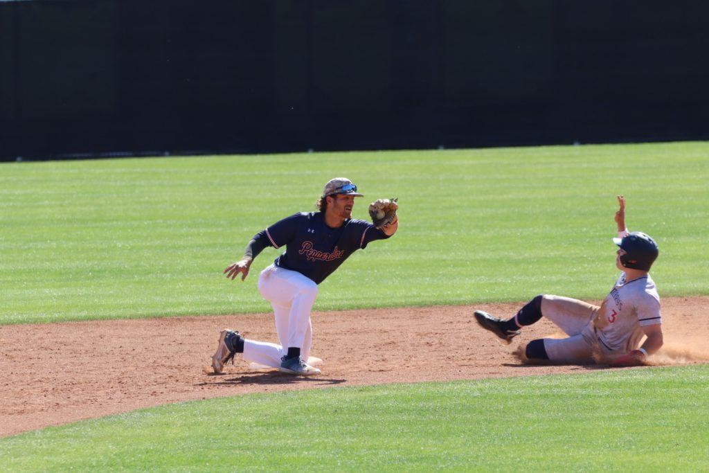 Former senior catching utility Ryan Johnson lunges to tag out an opposing player in a game against Cal State Fullerton at Eddy D. Field Stadium during the 2023 spring season. Johnson had a field percentage — a composite statistic made out of the sum of the number of outs and assists a player makes divided by the number of chances — of .962 during the 2023 season, according to Pepperdine Athletics.
