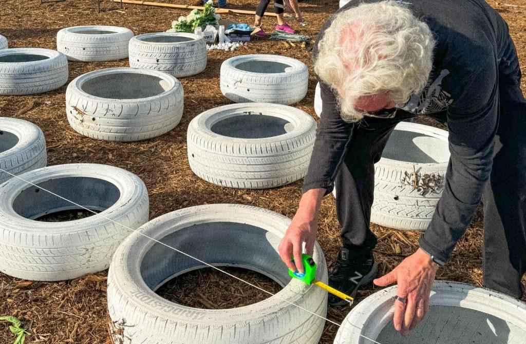 Michel Shane measures the distance between tires, Nov. 18. Shane said he hopes the ghost tire memorial encourages drivers to slow down on PCH.