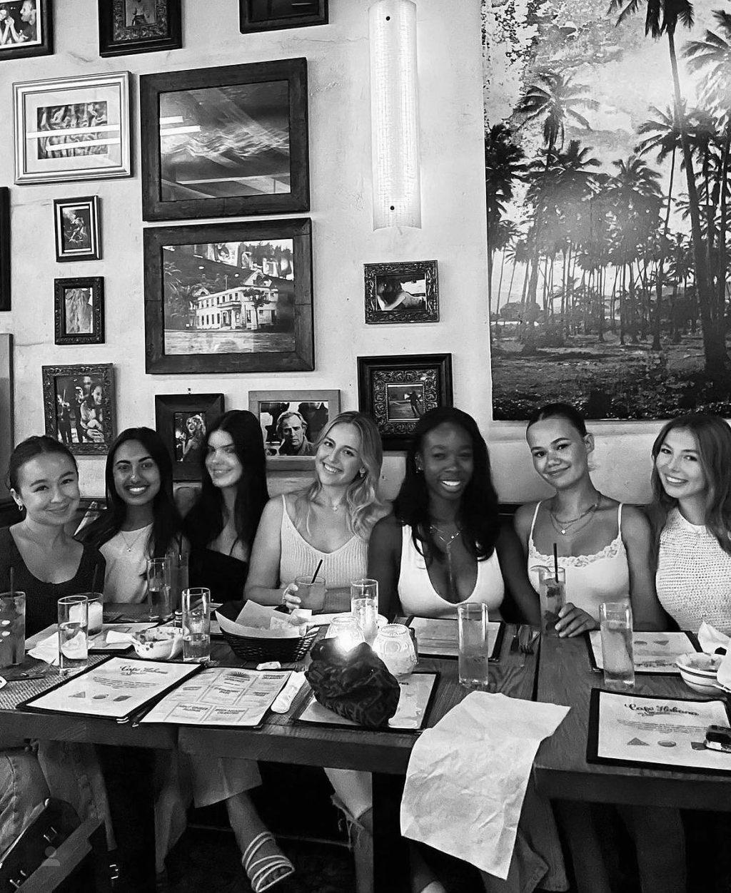 Asha Weir, Niamh Rolston, Peyton Stewart and Deslyn Williams pose with their Alpha Phi sorority sisters at a restaurant.