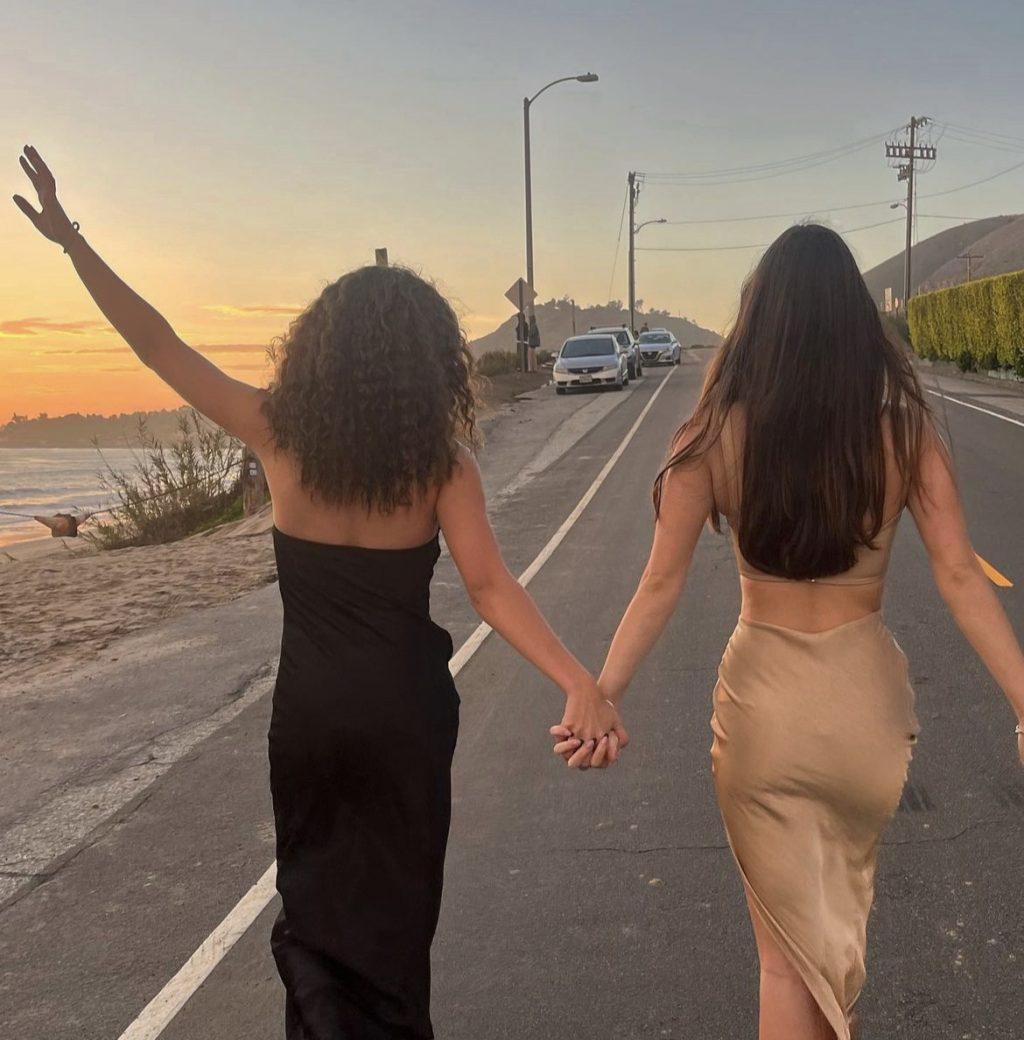 Senior Aubrey Lewis and Niamh hold hands during sunset.