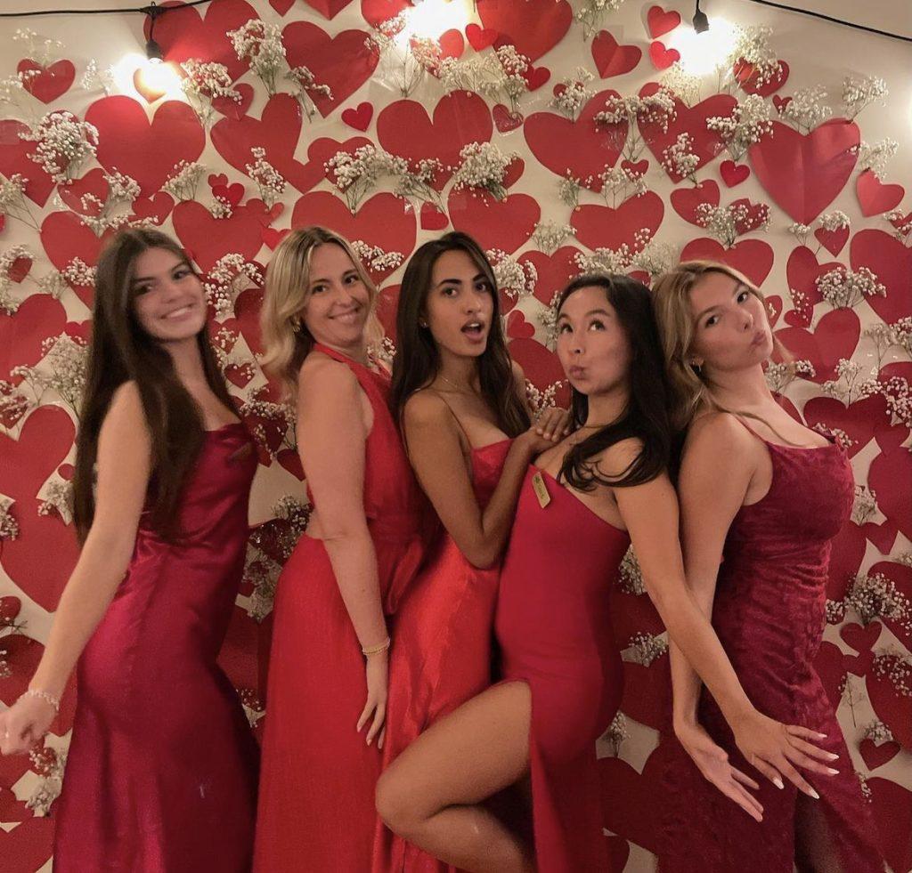 The girls pose with one another in APhi red dresses.
