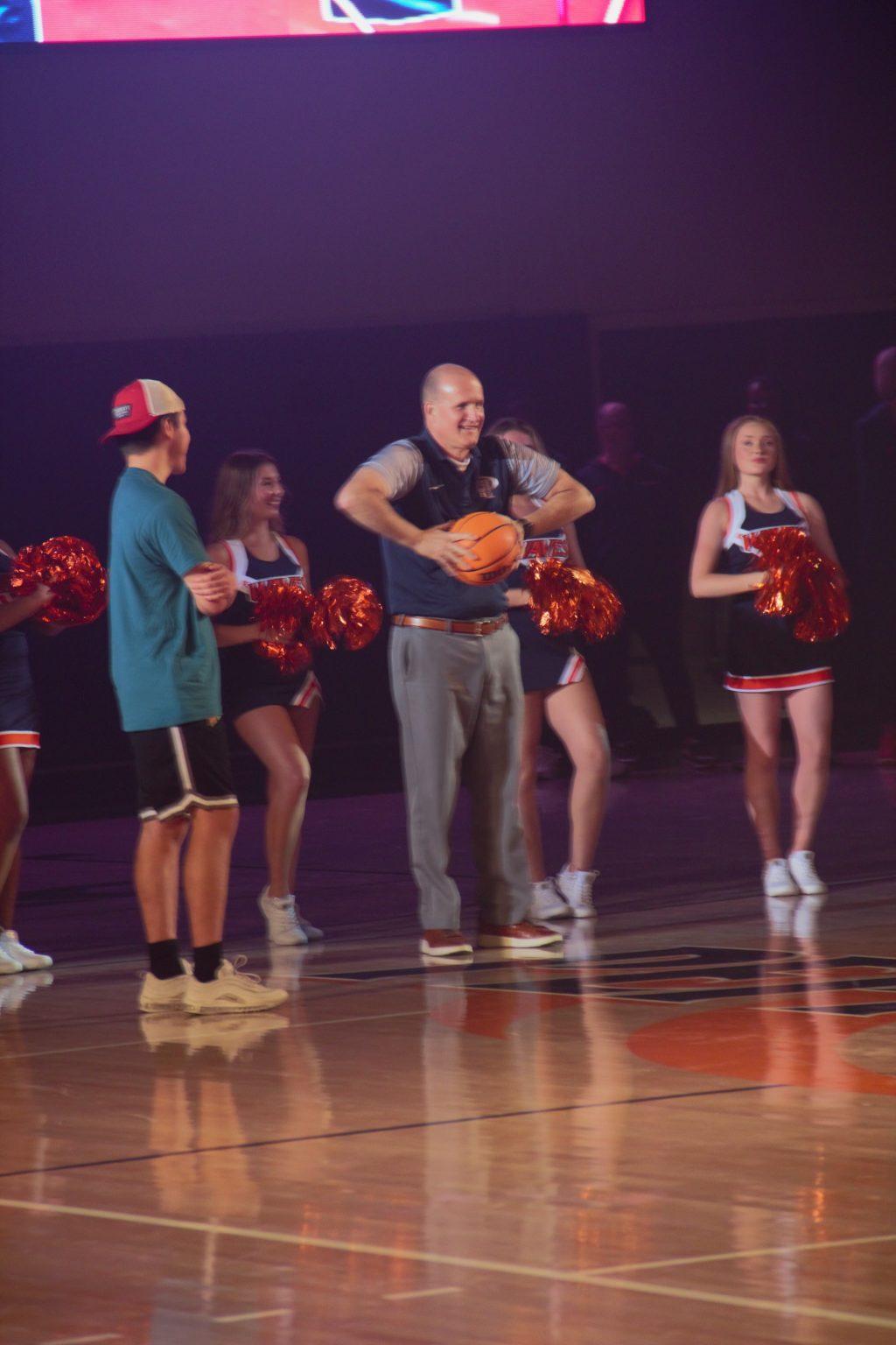 President Jim Gash getting ready to attempt a half-court shot that would eventually win sophomore Johann Luna a semester's worth of free tuition. The half-court shot for tuition is a tradition that takes place at Blue and Orange Madness each year. Photo by Lindy Smith