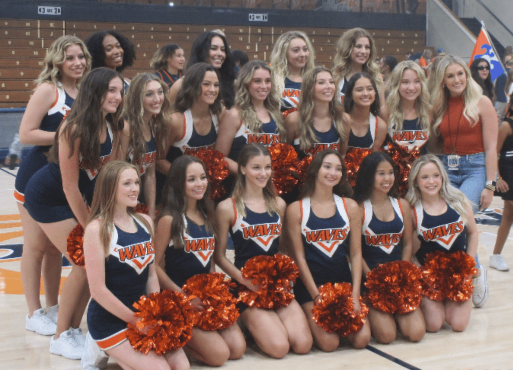 Janes takes a picture with the cheer team following their performance for Blue and Orange Madness at Firestone Fieldhouse in Oct. The team is entering its sixth season following a relaunch during the 2018-2019 season. Photos courtesy of Daphne Janes