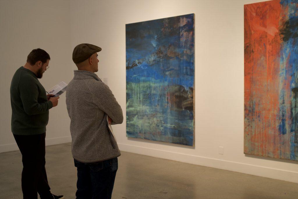 Two observers stand in front of the paintings "Between Two Waves of the Sea" and "The Fire and the Rose Are One" on Jan. 20, in the Weisman Museum. T.S. Eliot&squot;s "Four Quartets" inspired Fujimura for both works, and he completed them following a hiatus after surviving the 9/11 attacks in 2001, he said.