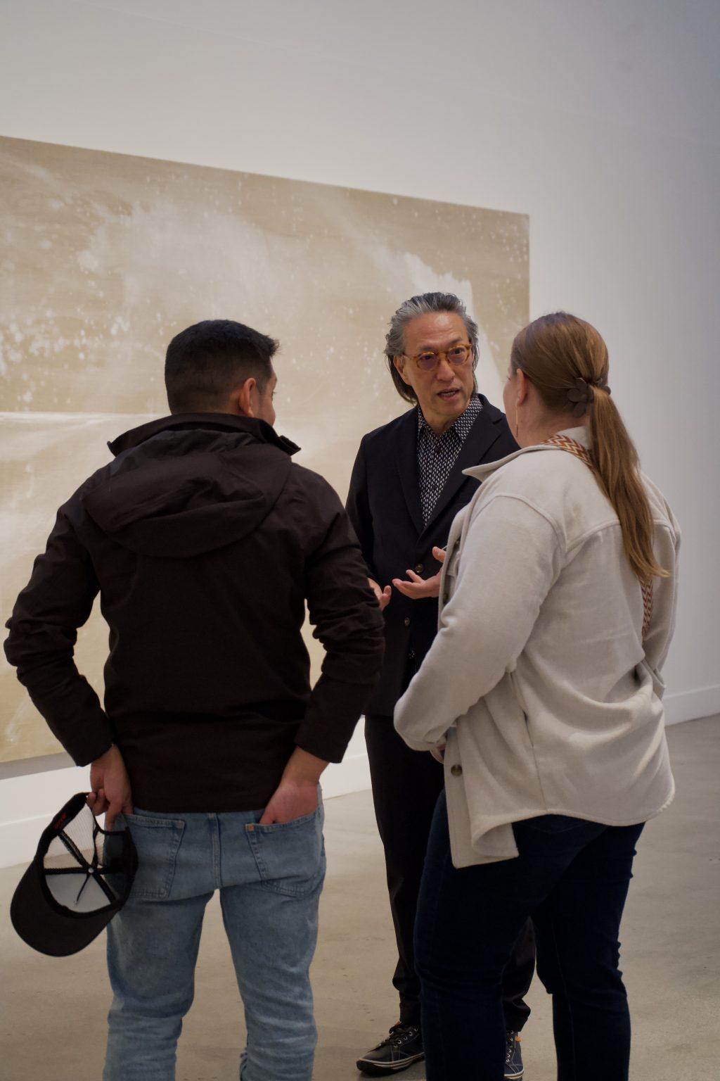 Fujimura discusses "Sea Beyond" with two observers Jan. 20, in the Weisman Museum. The massive triptych took up an entire wall within the Weisman Museum.