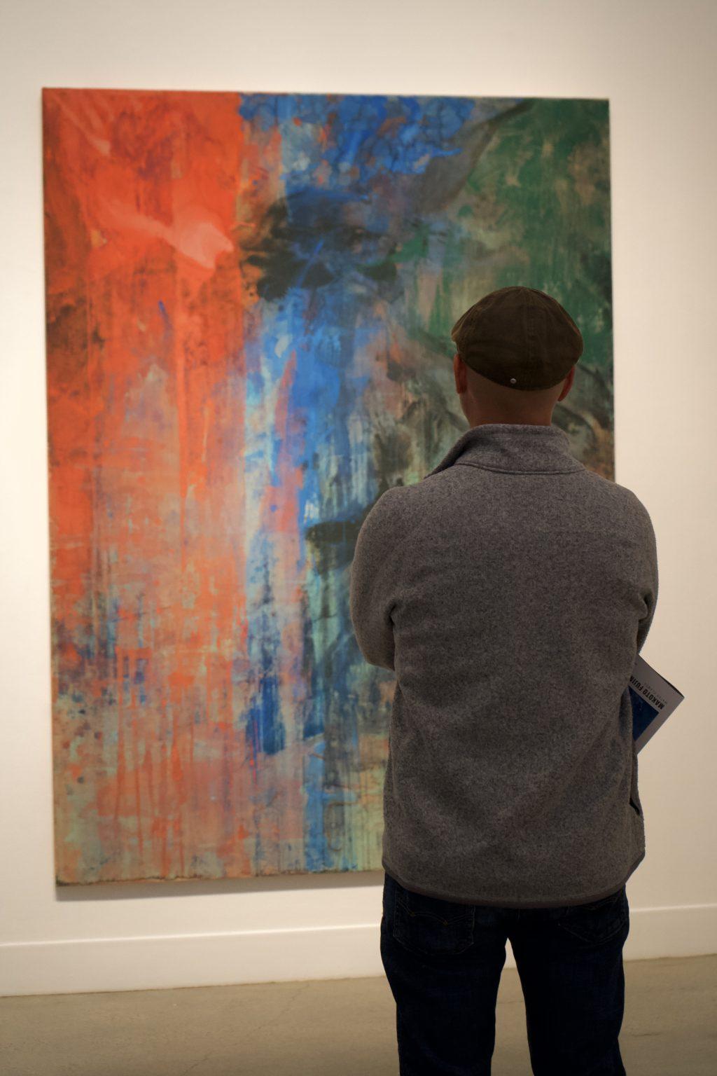An observer contemplates "The Fire and the Rose Are One" on Jan. 20, in the Weisman Museum. The explosion of colors featured vibrant red, blue and green shades that invigorated the canvas.
