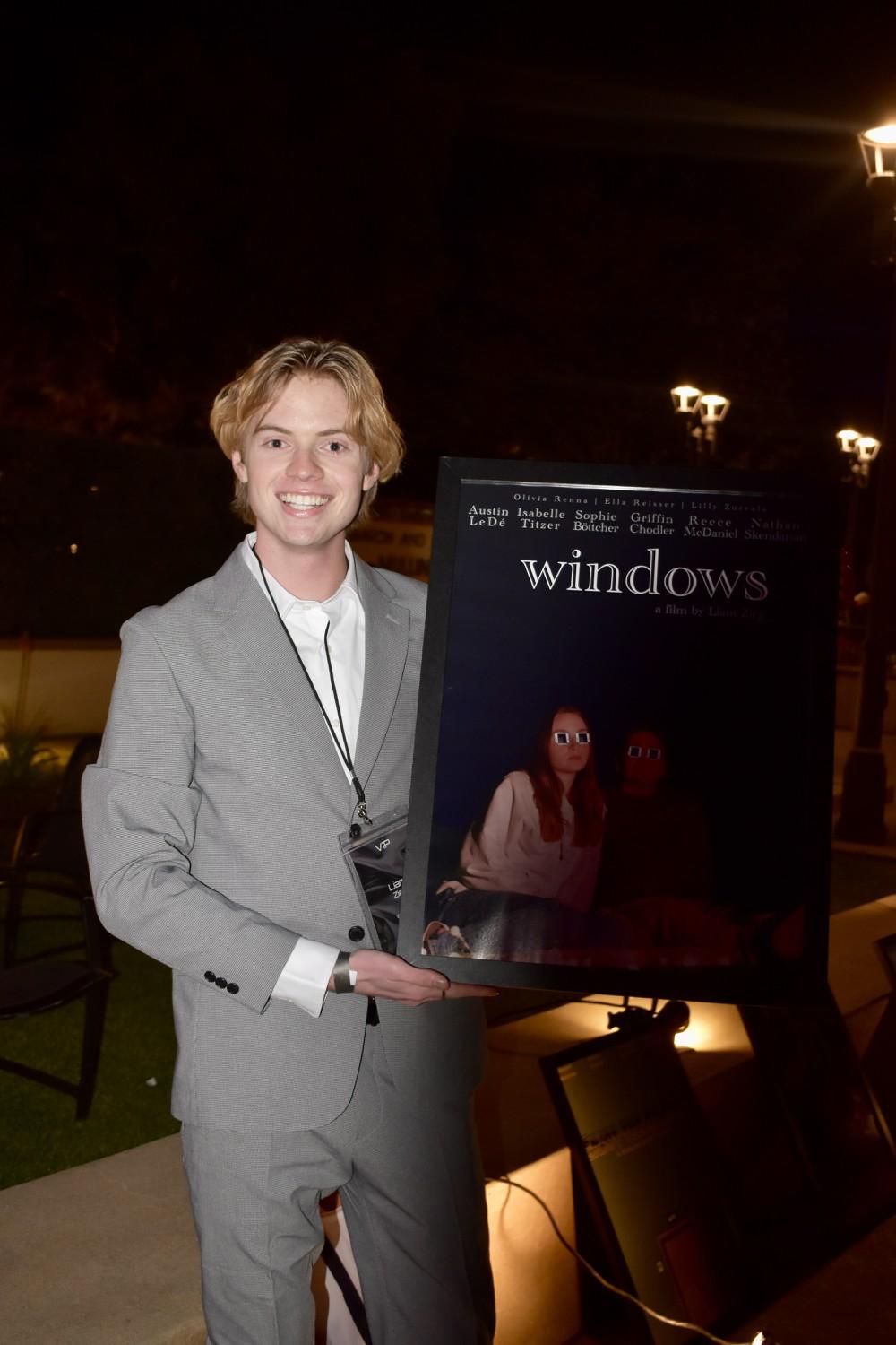 Junior Liam Zieg, assistant photo editor for the Graphic, holds the poster for his short film "Windows" on Feb. 9, in Upper Mullin Town Square. Zieg was the director, writer, cinematographer and editor of the film.