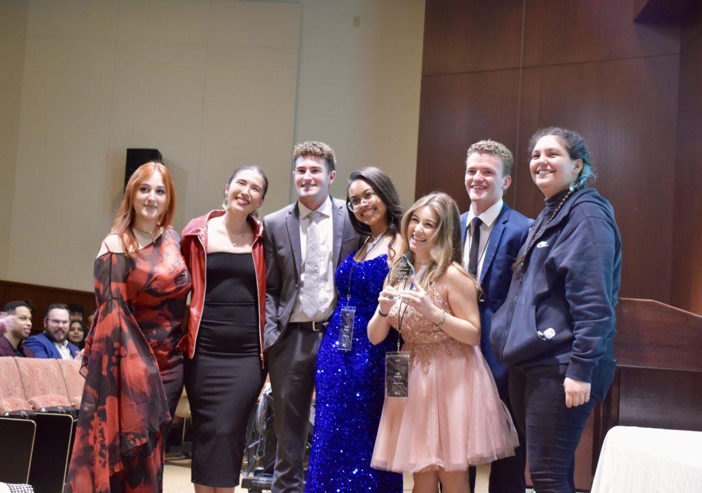 The crew of "Disconnected" stands at the front of Elkins Auditorium during the awards ceremony Feb. 9. Director Hali Orefice (third from right) invited her fellow crewmates Fatima Reyes (second from left), Nicole Fenshaw (middle) and Haley Castillo (far right) on stage to accept the award for Audience Choice.