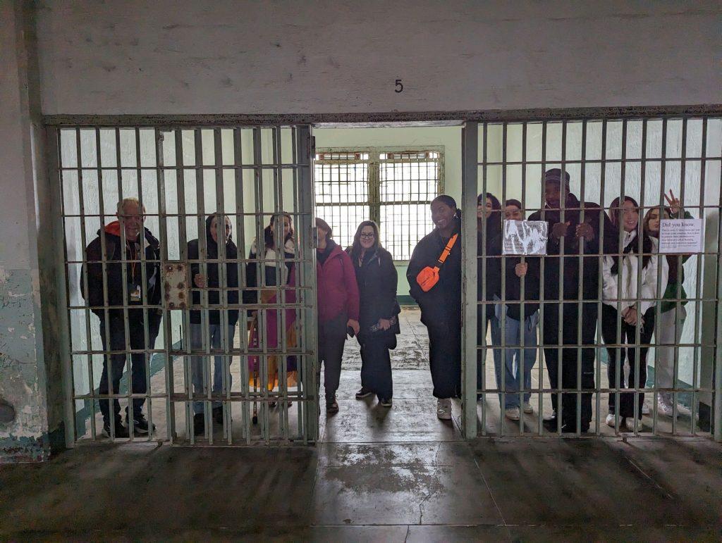 The Red Power student group poses behind a jail cell while getting a tour of the Alcatraz prison's abandoned hospital Jan. 13. After learning about the Red Power Movement, the students walked through sections of the prison that are usually off-limits to tourists. Photo courtesy of Myron McClure