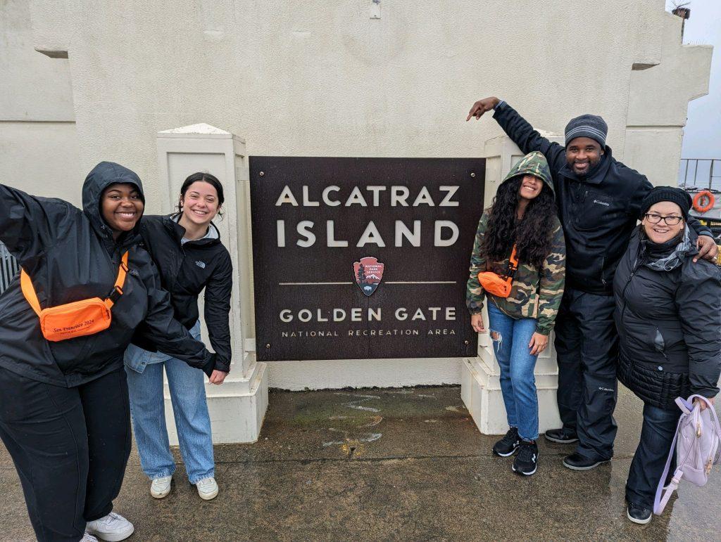 Several students from the Red Power Movement student group and two supporting faculty pose in front of the Alcatraz Island Golden Gate National Recreational Area sign Jan. 13. The group took a ship to Alcatraz Island to begin their educational experience. Photo courtesy of Myron McClure