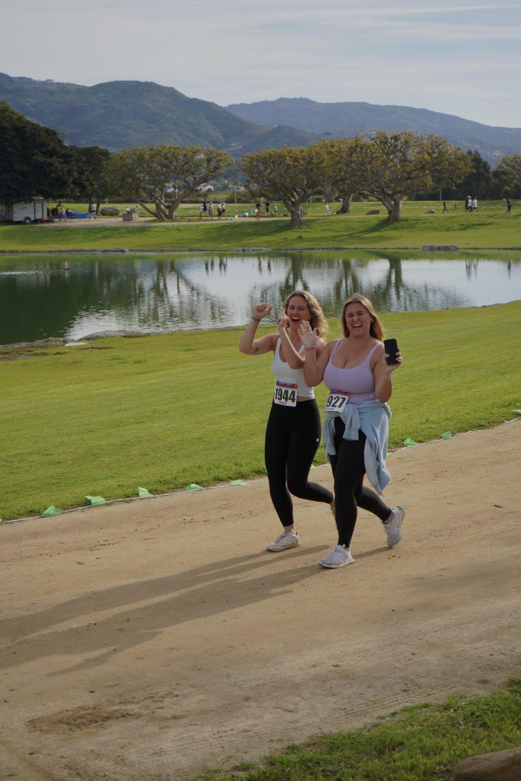 Attendees Maeve Muller (left) and Paige Scully (right) smile and cheer as they complete the 5K March 10, on Lower Alumni Field. Alpha Phi members encouraged participants on throughout the course.