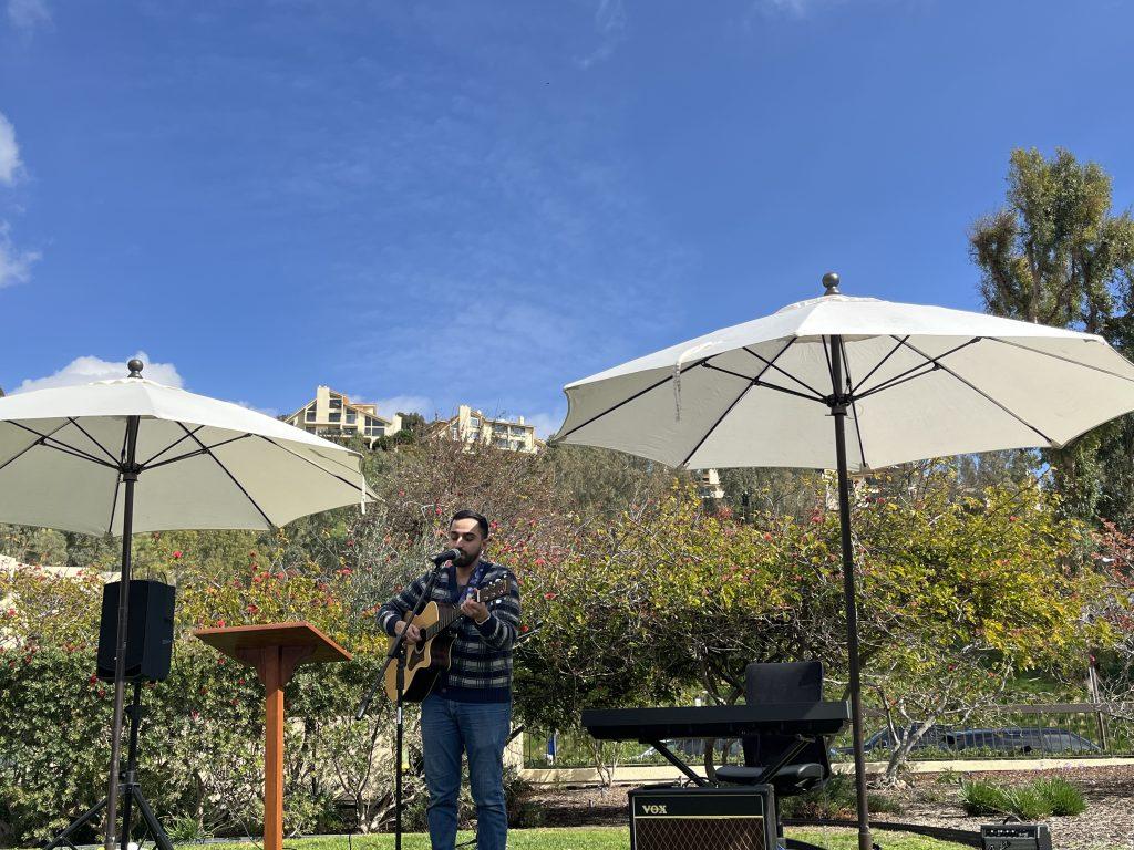 Frank Vazquez performs "Gratitude" in front of attendees on the front lawn of the Caruso School of Law on Feb. 14. Vazquez also helped other acts with their music, equipment and microphones. Photo by Viviana Diaz