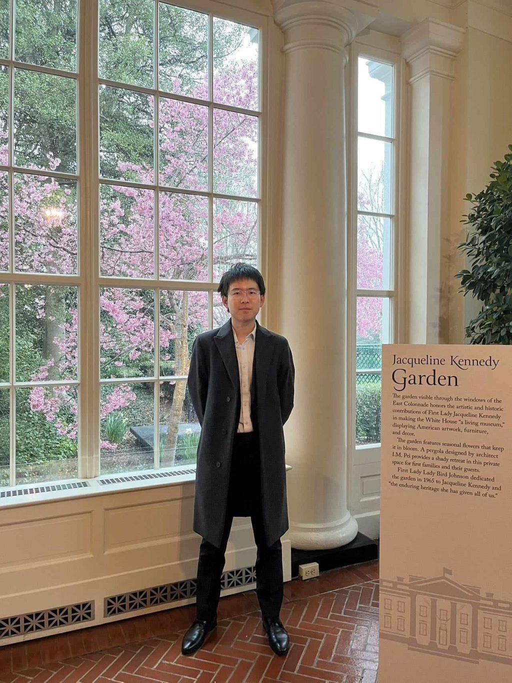 Junior Bill Qiu stands before the Jacqueline Kennedy Garden during the White House tour Feb. 27. With the National Cherry Blossom Festival happening later in March, cherry blossom flowers were already beginning to bloom in the city. Photo courtesy of Bill Qiu