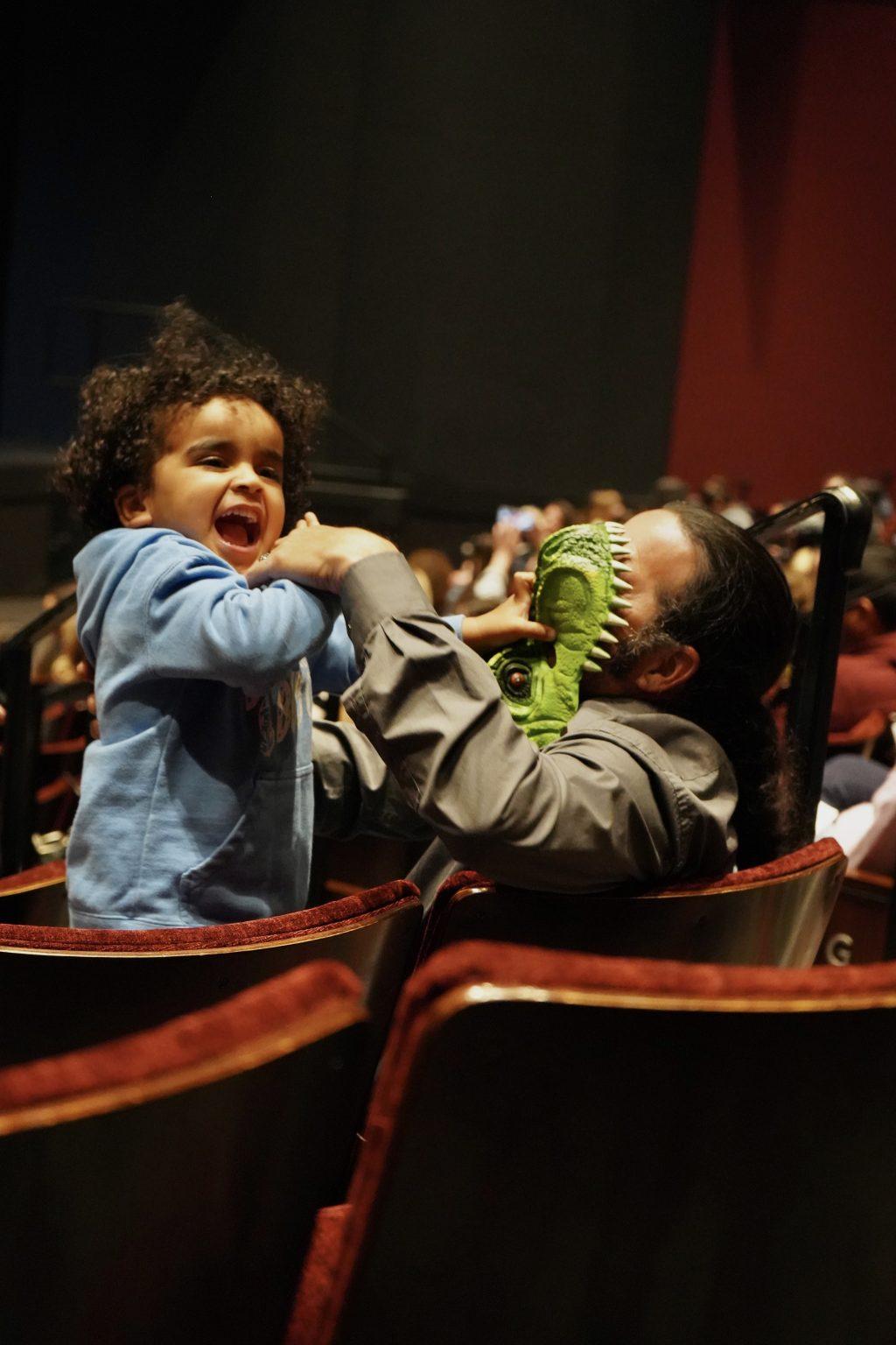 A child with his dad anticipates the show in Smothers Theatre on March 8. Before being seated, they bought "Dinosaur World Live" merchandise from a kiosk in the reception area.