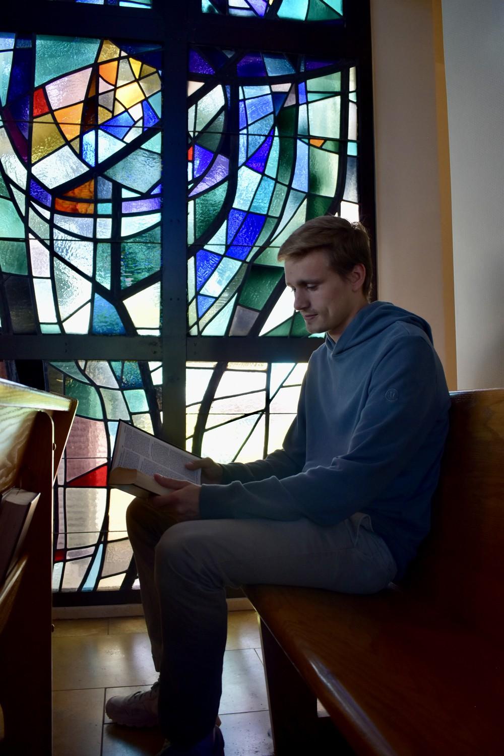 Junior Brent Long sits and reads the Bible in Stauffer Chapel. Long said his faith has been challenged while at Pepperdine.