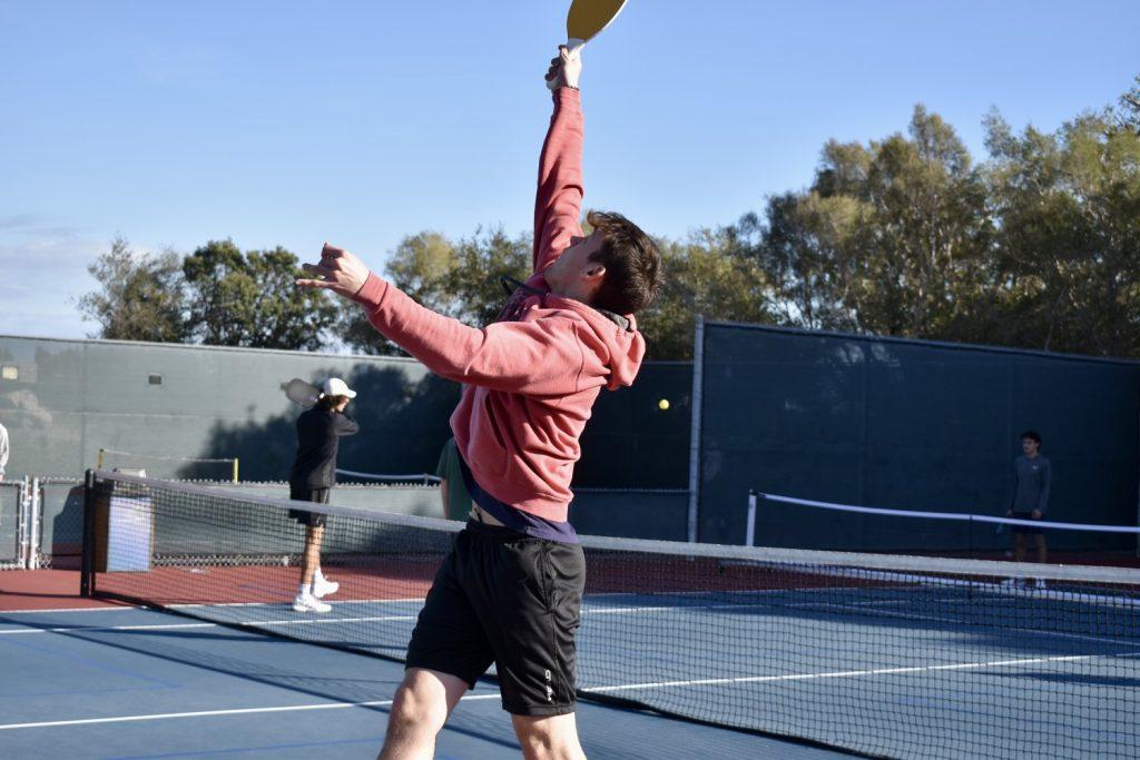 Senior Brishen Williamson jumps in the air to receive a ball Feb. 10, at Lower Alumni Courts. Fitness is a driving factor behind students' motivation to join Pepp Pickle, Lorimer said. Photo by Mary Elisabeth
