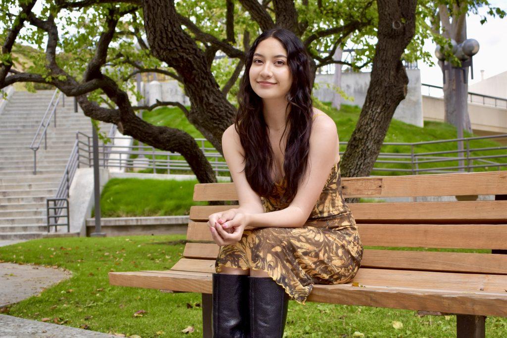 Junior Sofia Reyes smiles on a bench outside Payson Library on March 24. Reyes said she wants to create a space at Pepperdine to celebrate people's identities. Photo by Mary Elisabeth