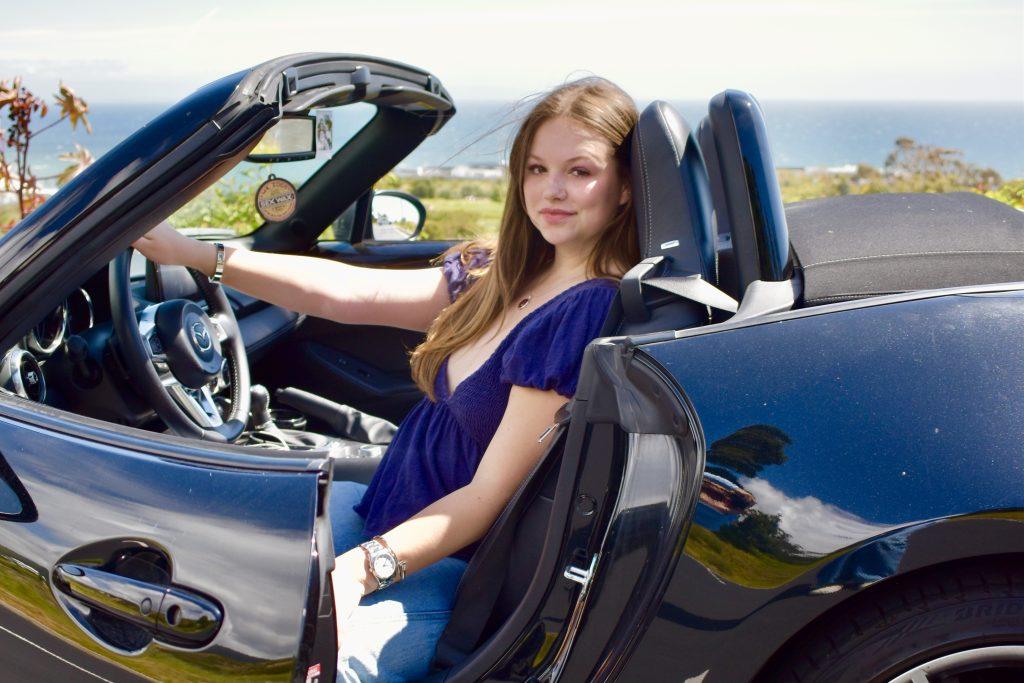 First-year Claire Taylor poses in her 2022 MX5 Mazda Miata on March 23. Taylor said she inherited her love of cars from her dad. Photo by Mary Elisabeth.