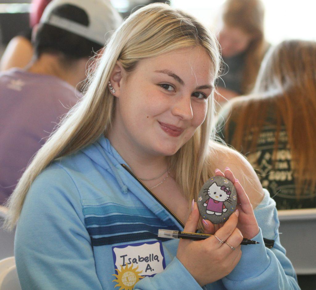 First-year Bella Alfonso poses with her Hello Kitty-designed rock at the Creative Cafe on March 23, in the Fireside Room. Many students colored animals, mandalas or characters on their rocks.