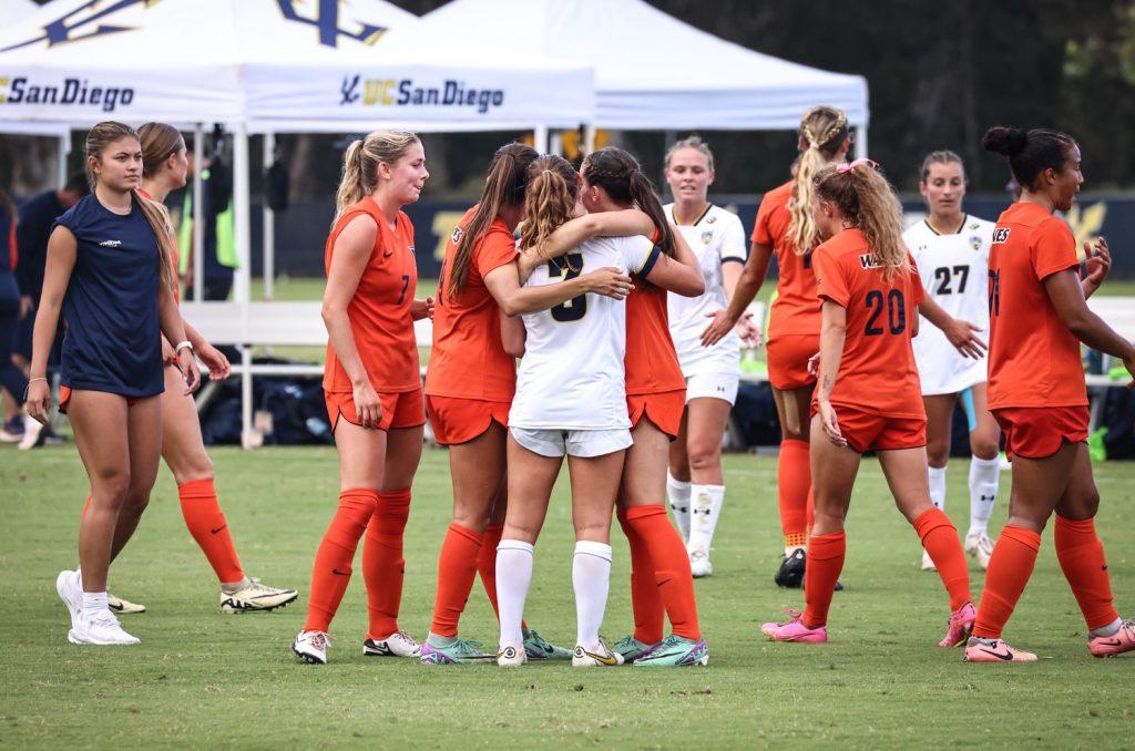 Member's of Women's Soccer embrace former Wave and alumna, Skyler Enge ('24), after their match against one another Aug. 22. Enge was a Wave for four seasons before joining UCSD as a graduate student midfielder for the 2024-25 season.