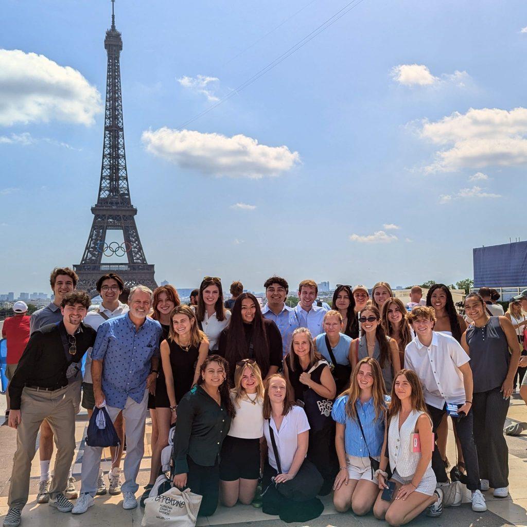 The Paris Olympics Program students group together for a photo in front of the Univision Broadcast Center in the Trocadéro area in Paris on July 27. The group spent three weeks together in Paris, having classes throughout the week, and the freedom to travel and explore on their off days. Photo courtesy of William Alhadeff