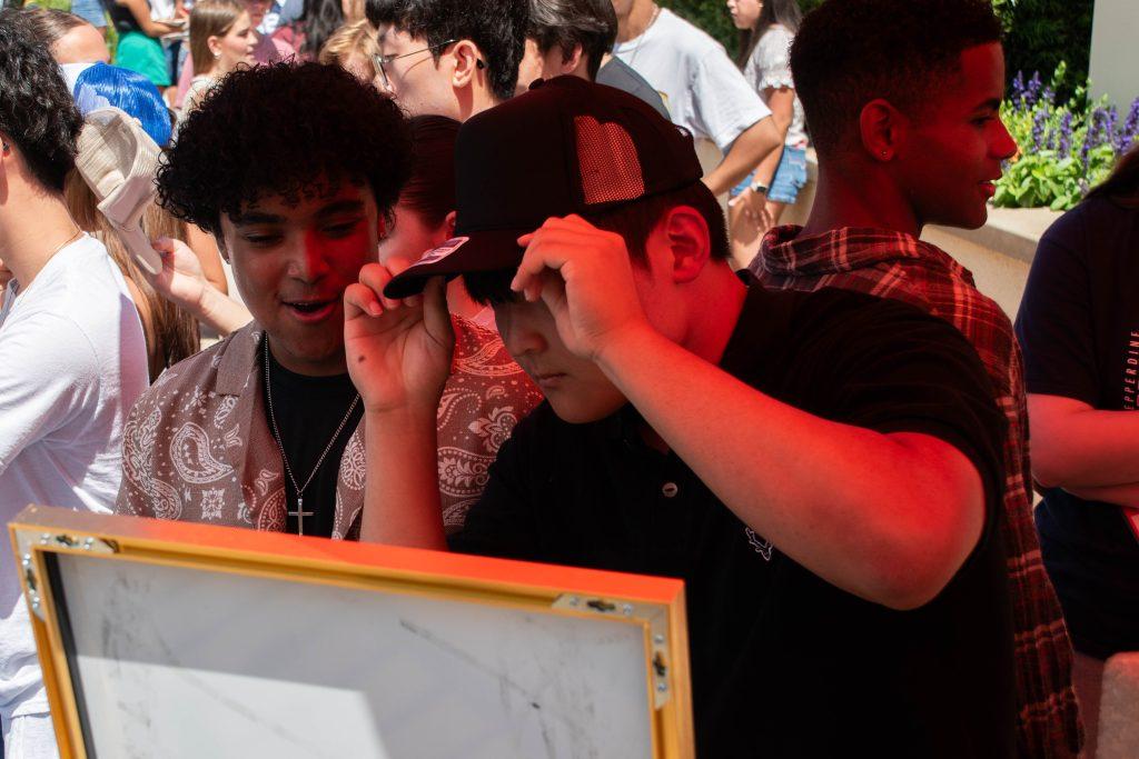 Two first-years check out their new personalized trucker hats at the NSO Block Party on Aug. 16 in Mullin Town Square. This gathering also held space for organizations such as RISE and Community Engagement and Service.