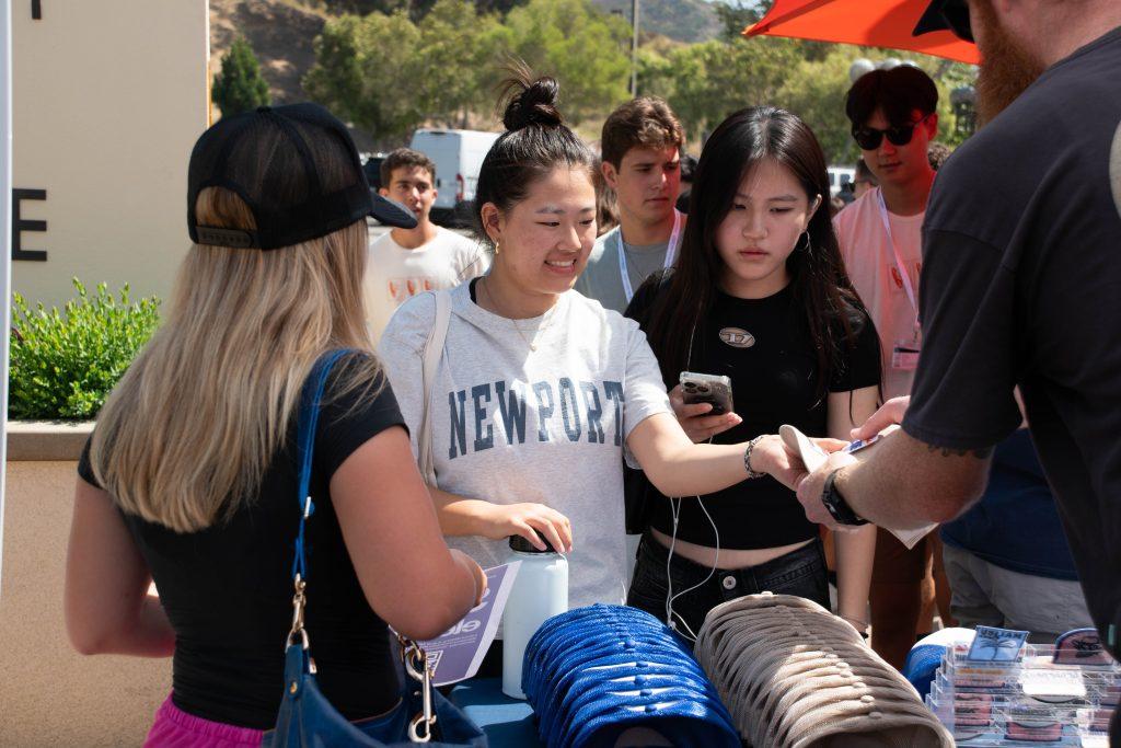 First-year students are handed their customized trucker hats at the NSO Block Party on Aug. 16 in Mullin Town Square. The fashion booth was spearheaded by SGA as a means to create new designs for the Pepperdine bookstore. Photos by Perse Klopp