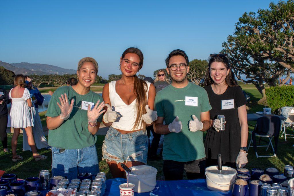 Alumni and student leaders preparing to hand out mugs