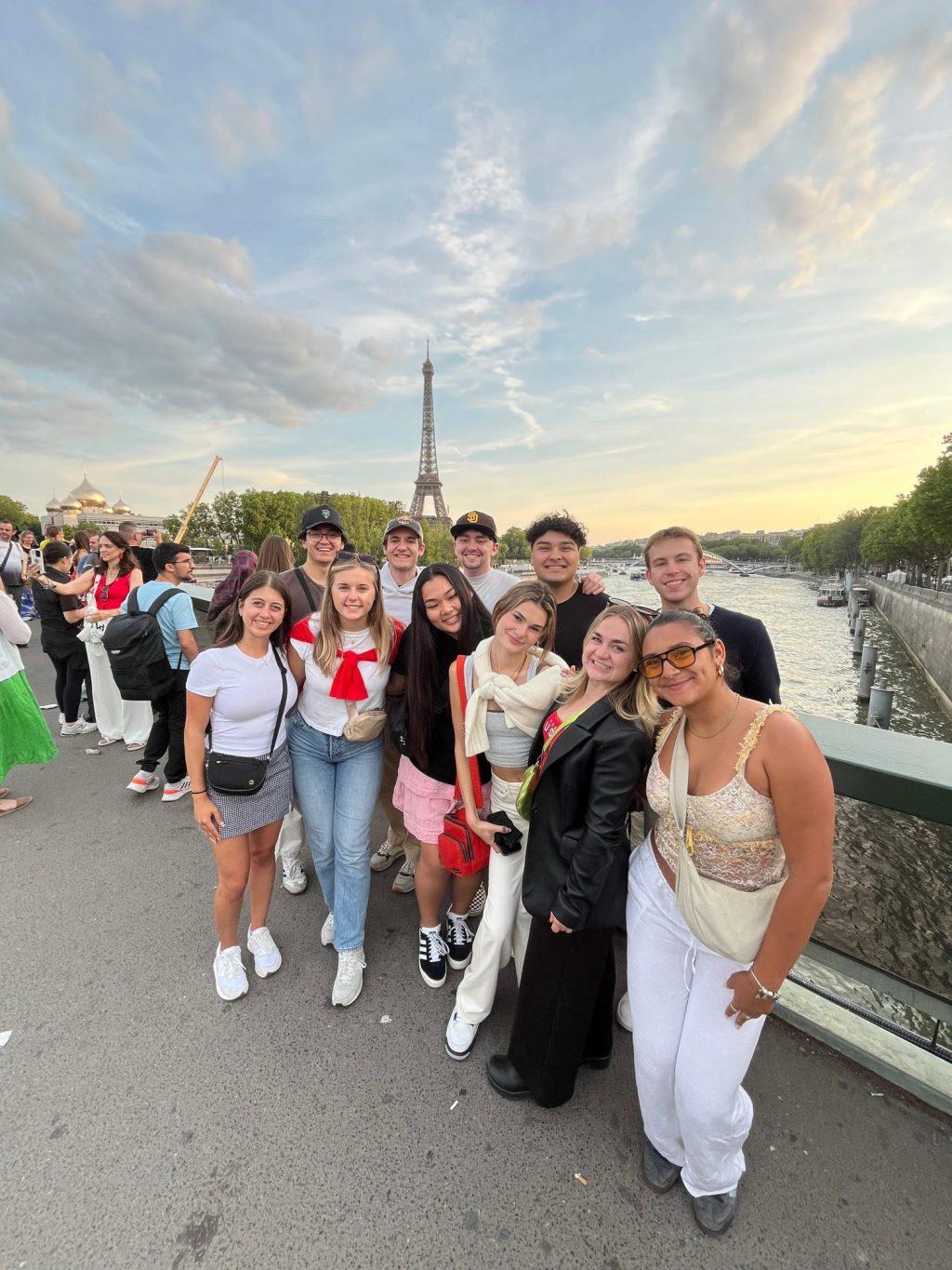 A group of Paris program students get together for a photo along the Seine River on July 17. Students preferred to explore the city in groups, allowing them to create worthwhile relationships that extend beyond Paris, many students said. Photo courtesy of the Paris program