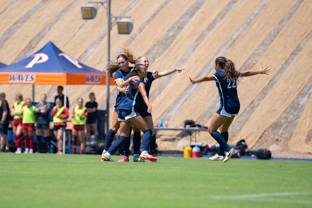 Graduate midfielder/forward Tori Waldeck celebrates with her team after scoring a goal against USC on Aug. 25, at Tari Frahm Rokus Field. Waldeck points toward sophomore forward Julia Quinonez who assisted the goal. Photos courtesy of Pepperdine Athletics