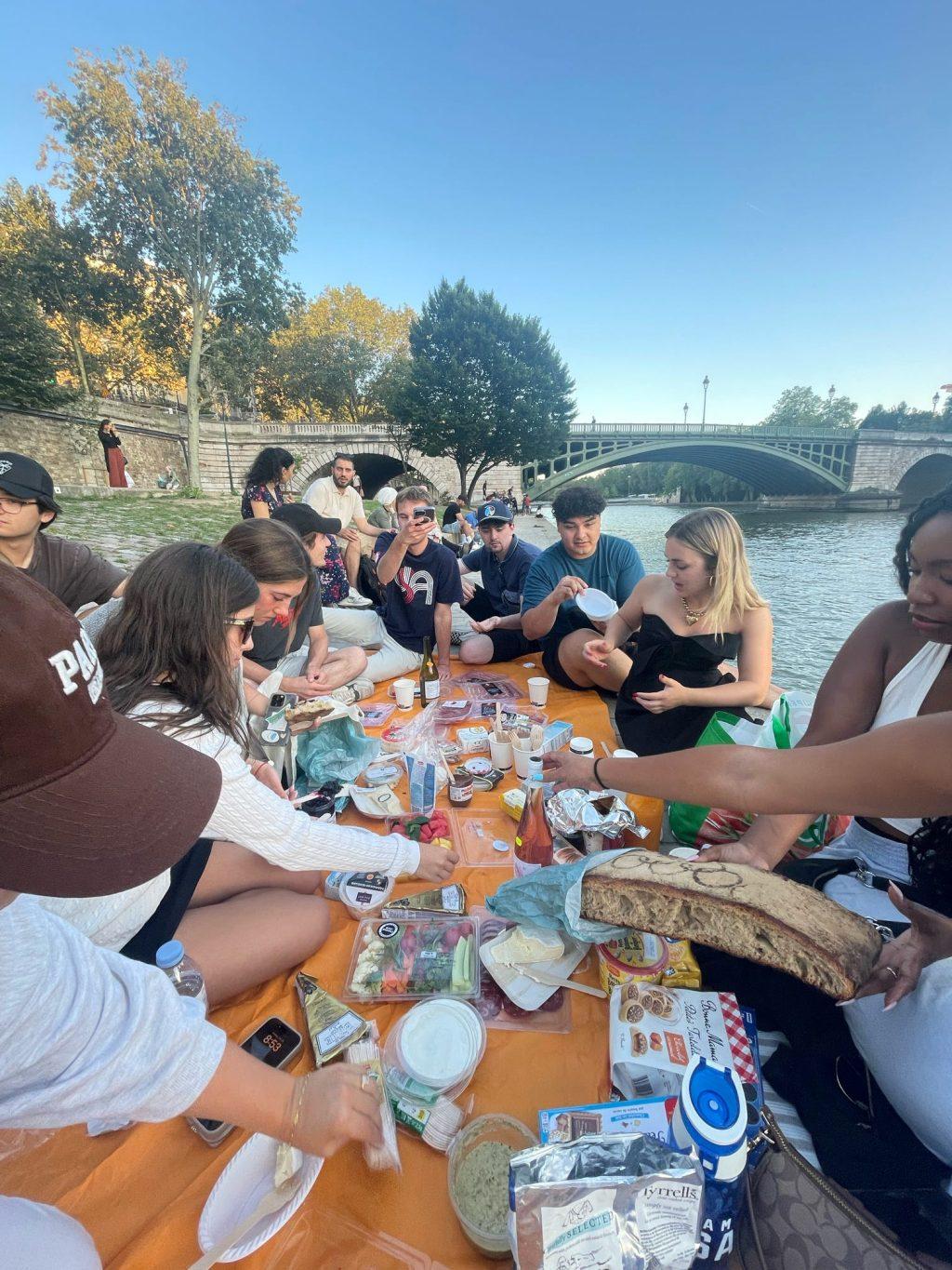 The Paris Program students enjoying the day with a picnic along the Seine River on July 28. Relationships were created and bonds were built between students in Paris, many students said. Photo courtesy of the Paris program