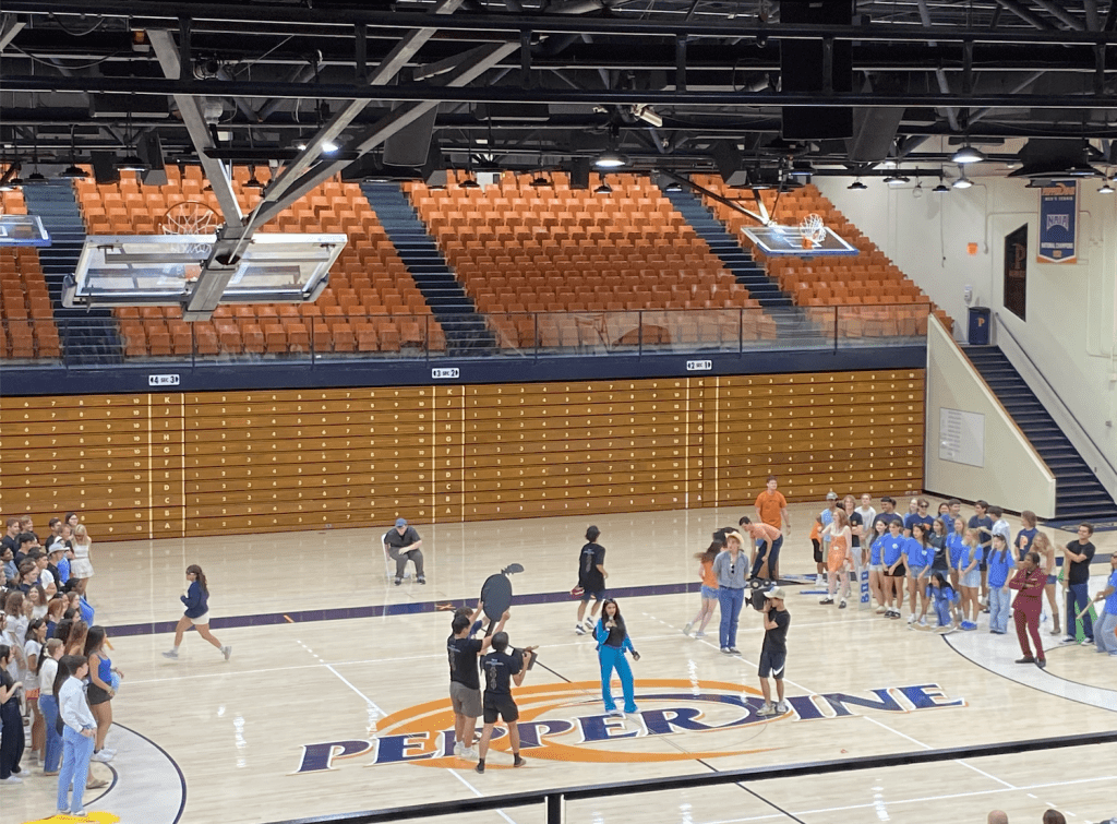 The popular song "Brat" by Charli XCX plays on the background of character "Los Angeles&squot;" introduction speech in Firestone Fieldhouse on Aug. 17. Los Angeles participated in "The Golden Bachelor" to find Pepperdine&squot;s mascot in skit by houses Conner, Peppers, E. Pen, Hayes, Seaside.