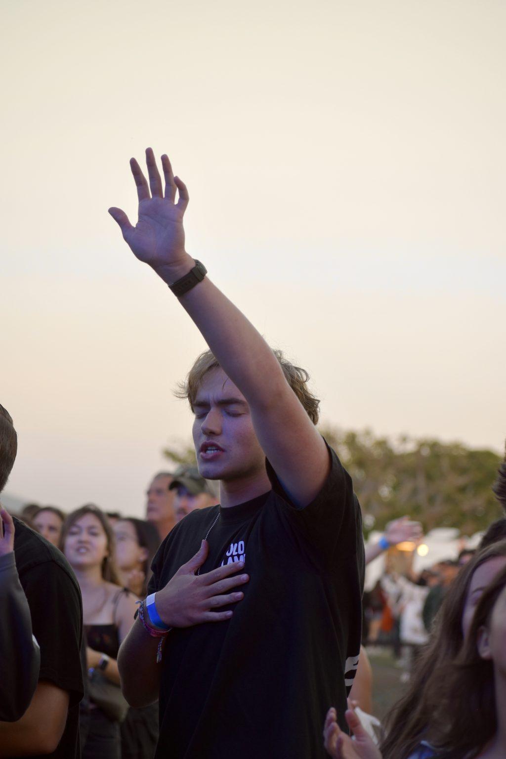 First-year Zane Worth held his hands in the air during the Sept. 14 Worship Summit on Alumni Park. Worth was one of 5,000 audience members of the evening.