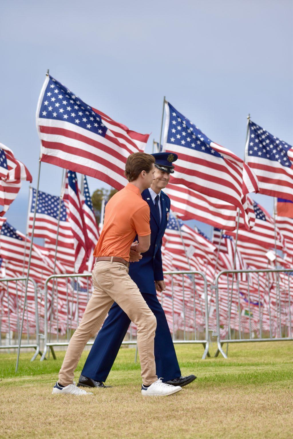 Samuel Miller and Eric Leshinsky (pictured left to right) place the final flag in the Waves of Flags instillation. The tradition began last year with Chris Pratt placing the final flag.