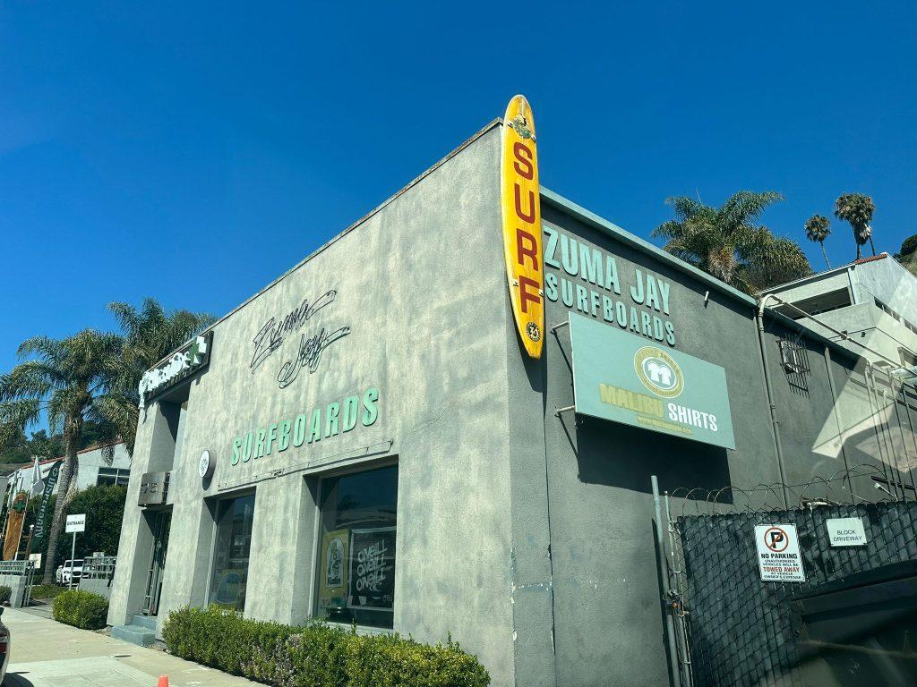 Zuma Jay's Surfboards' distinctive yellow sign in the shape of a surfboard hangs on the wall of the store located off PCH on Sep. 5. Students were drawn by the shop's convenient location and rented boards for the day. Photo courtesy of Ines Villarreal