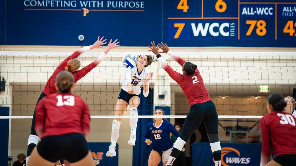 Freshman middle blocker Ella Pikorz attacks the middle of two blockers against the No. 2 Stanford Cardinals on Sept. 11 at Firestone Fieldhouse. Pikorz had five kills against the top-10 matchup as a freshman.