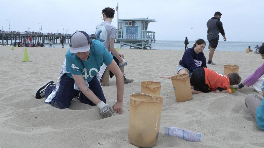 Volunteers sift through sand looking for trash at the Santa Monica Pier coastal cleanup site Sept. 21. Heal the Bay provided volunteers with gloves and buckets. Photo by Nora Moriarty-McLaughlin