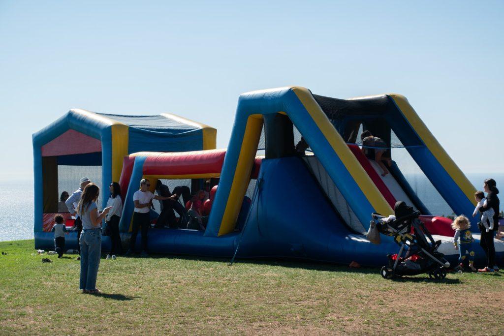 Children bounce in the bouncy house on Oct. 20 at Alumni Park. There were carnival games and food trucks set up for the attendees to enjoy.