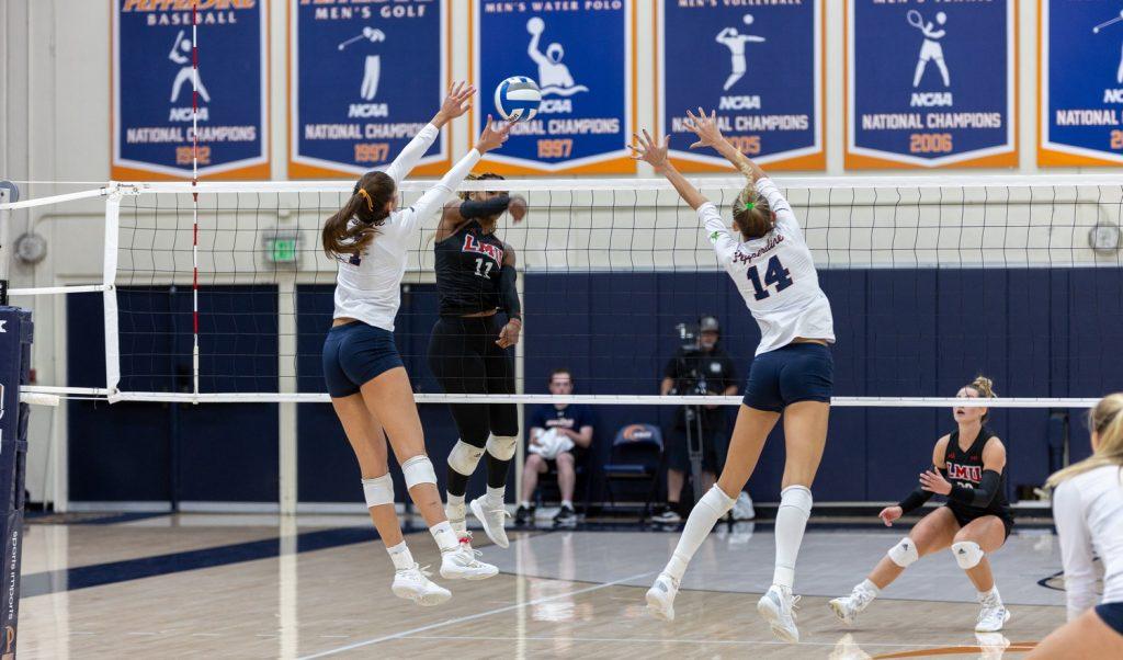 Senior outside hitter Grace Chillingworth and junior middle Kenadie Patterson jump for a block against an LMU hitter Nov. 7 at Firestone Fieldhouse. Patterson had five blocks against the Lions.