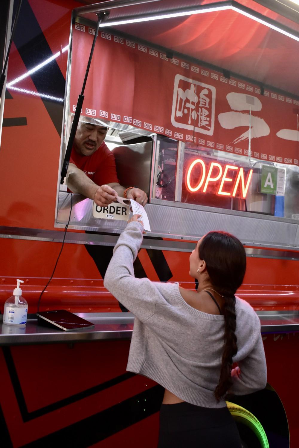 A student receiving her ramen at Stick-or-Treat on Oct. 24 at the SHC. Students had the opportunity to receive free ramen after getting their flu shot.