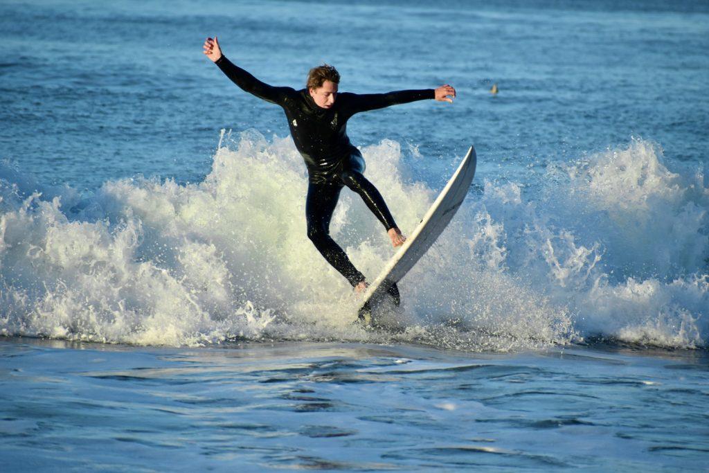 Junior Chris Sottile rides a wave during a Wednesday morning practice at Zuma Beach on Oct. 30. The team has a mix of men and women surfers.