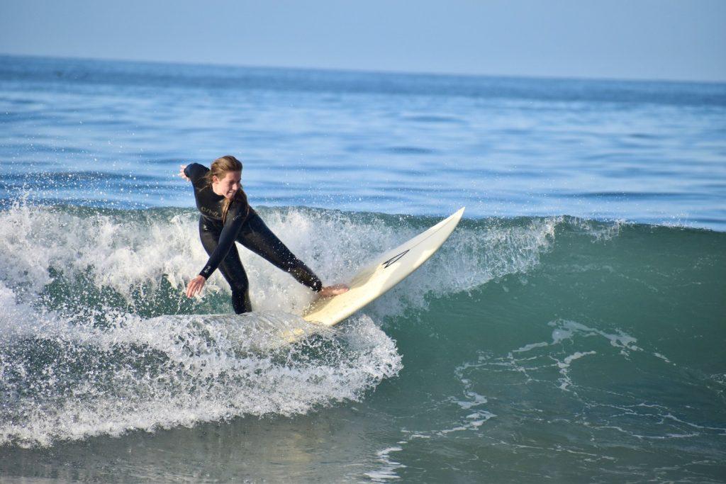 Senior Cat Sayne catches a wave at Zuma Beach on Oct. 30. While the team only practices once a week together, Head Coach Joe Rickabaugh said this is more than many other club surf teams.