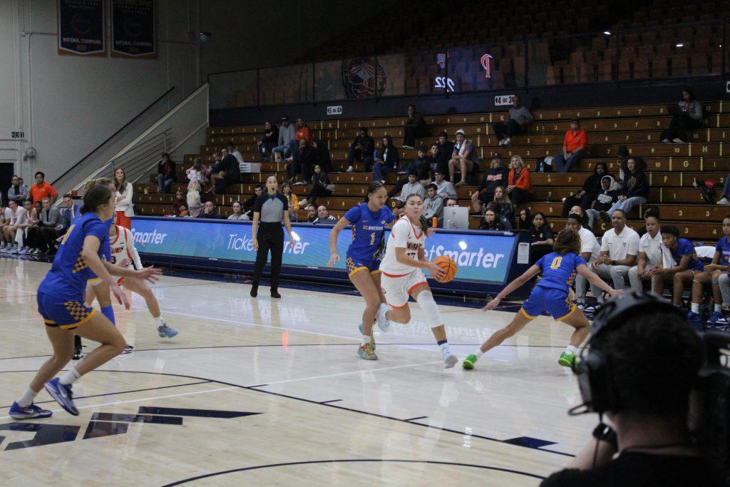 Senior guard Makena Mastora drives to the paint looking for a layup against the Highlanders on Nov. 18 at Firestone Fieldhouse. Makena finished the night with eight points.