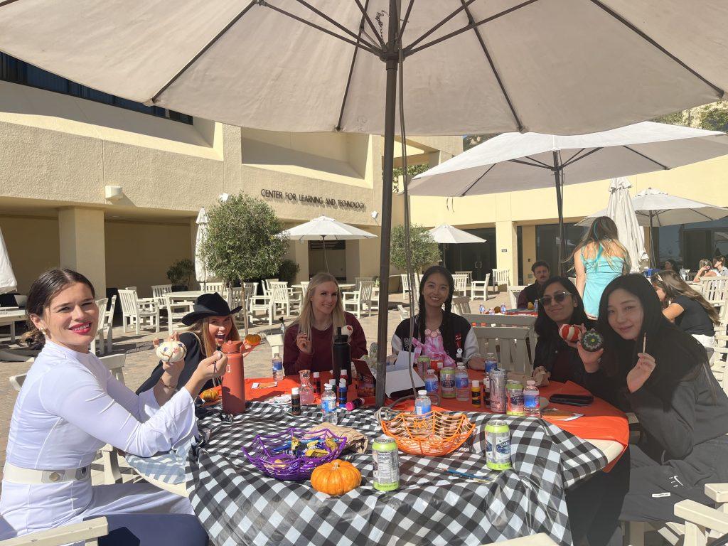 GSEP students sit with RISE graduate assistant Molly Adams while decorating their pumpkins at Gulls Way Patio on Oct. 31. The students talked about their class and decoration choices. Photos by Viviana Diaz