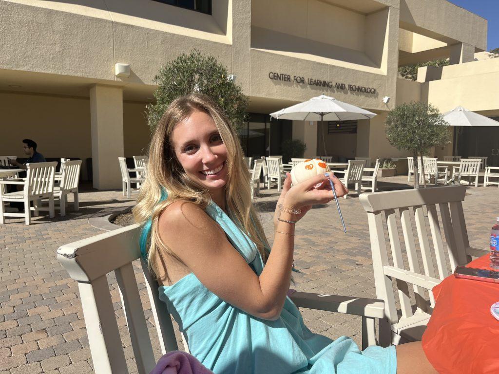 Christen poses with her pumpkin at Gulls Way Patio on Oct. 31. Christen said the event was nice to step out to, given that she and her classmates had just discussed deep subjects in their psychology class.