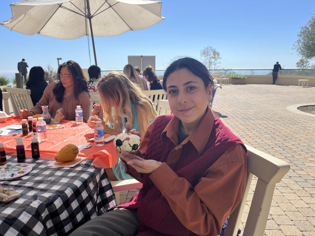 Merriam holds her pumpkin at Gulls Way Patio on Oct. 31. She was dressed as her professor for Halloween.