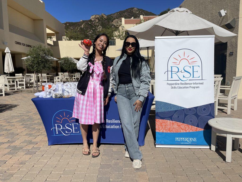 Graduate student Maha Ishaq with another graduate student, Wenting Zhu, posing for a picture together at Gulls Way Patio on Oct. 31. Ishaq said the event was a way to step away and meet people outside of her full-time MBA program.