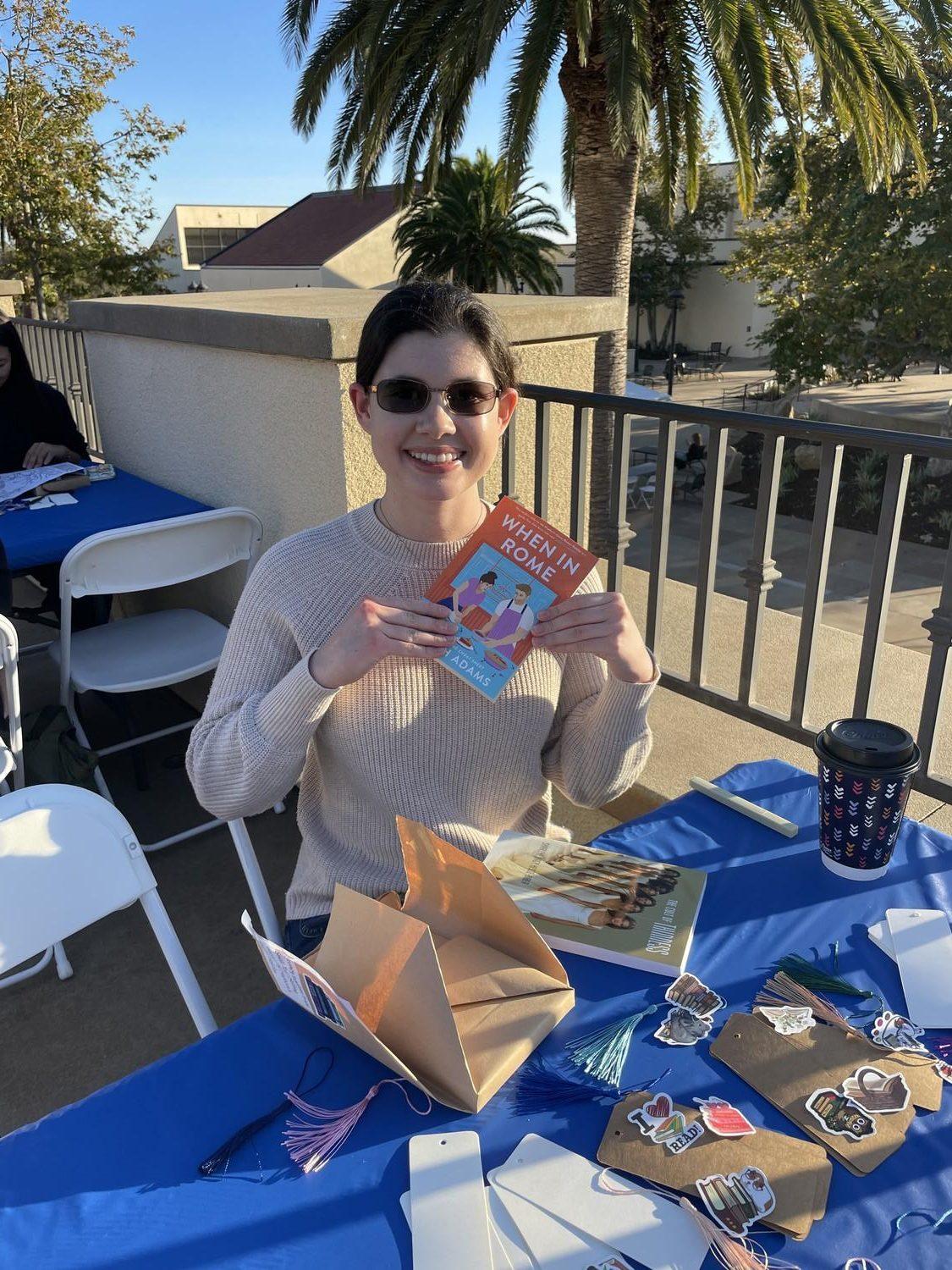 Elizabeth Starkey holds the book she received from the Blind Date with a Book event. The book is called When in Rome by Sarah Adams. Photo by Mackenzie Krause