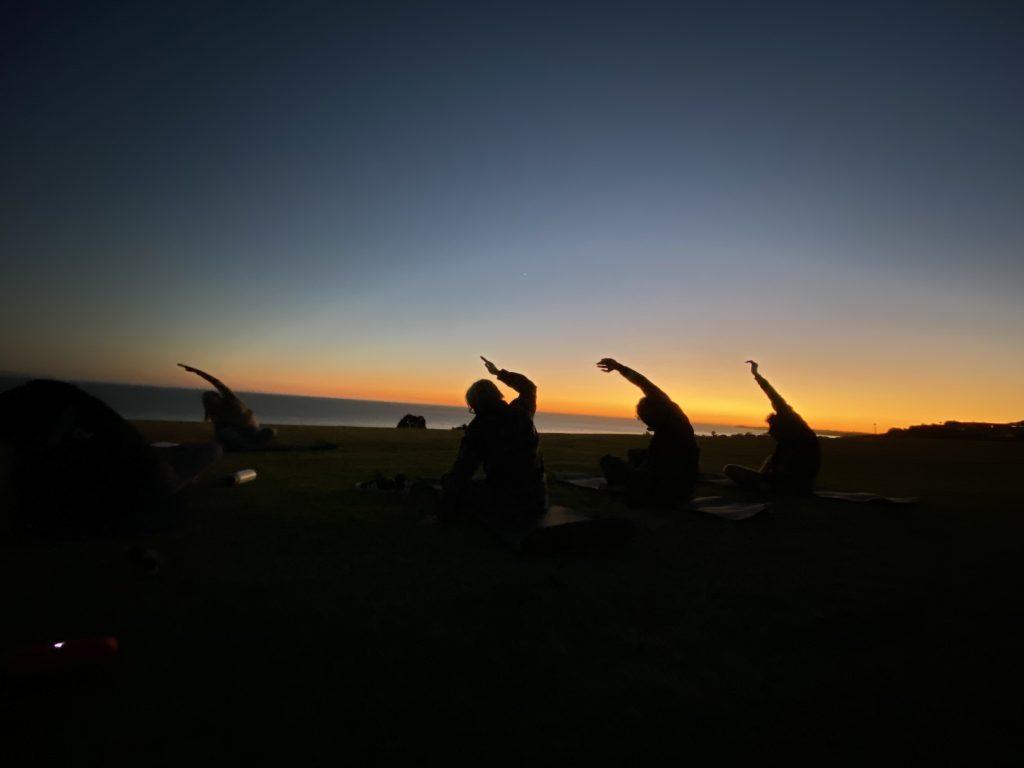 Waves of Silence members do side stretches at the Nov. 13 club meeting on Alumni Park. Senior Physics major Julia Johnson instructed yoga for about 20 minutes. Photo courtesy of Lydia Smith