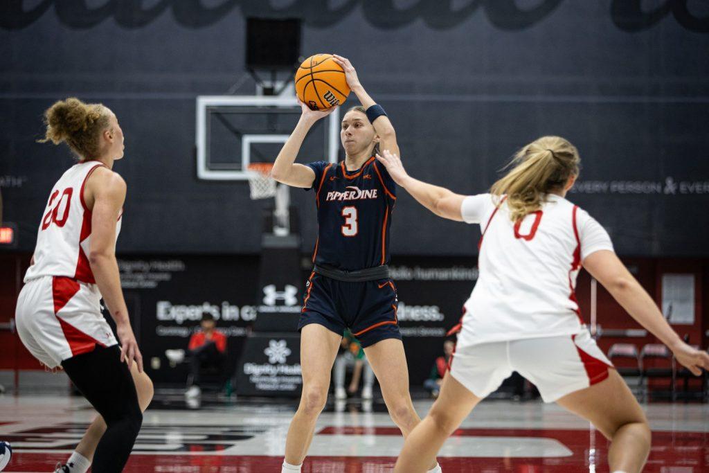 Graduate guard Ella Brubaker looks to pass the ball over two CSUN guards Nov. 27 against the Matadors at Premier America Credit Union Arena. Brubaker had her own career high Nov. 18 against the University of California, Riverside, with 20 points, following up with 14 points in the win over CSUN.